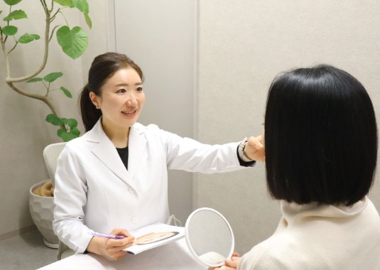 患者様と鏡を見ながら話す院長